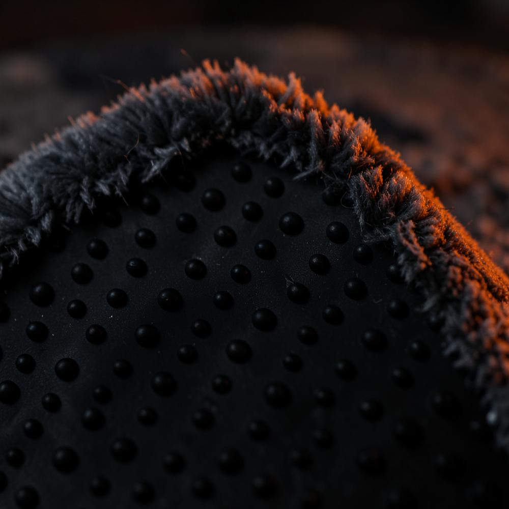 Close-up of the rug's dotted rubber non-slip backing next to its soft plush pile edge